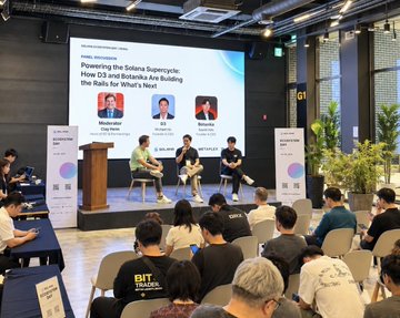 A conference panel session on a stage with an audience seated in rows, featuring a screen titled 'Powering the Solana Supercycle: How D3 and Rokafka Are Building the Rails for What's Next' with speakers Modulpr, D3, and Rokafka.