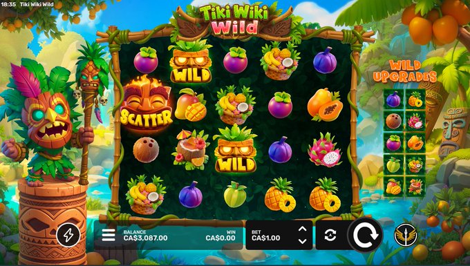 A vibrant online slot game titled "Tiki Wiki Wild" by ValkyrieXStudio is displayed, showing a tropical-themed interface with various fruit and tiki mask symbols, a current balance of CA$5,087.00, a bet of CA$1.00, and a win of CA$0.00. The image perfectly aligns with the promotional post announcing the new game's release and encouraging followers to drop their stake usernames for a chance to be tipped from the balance.
