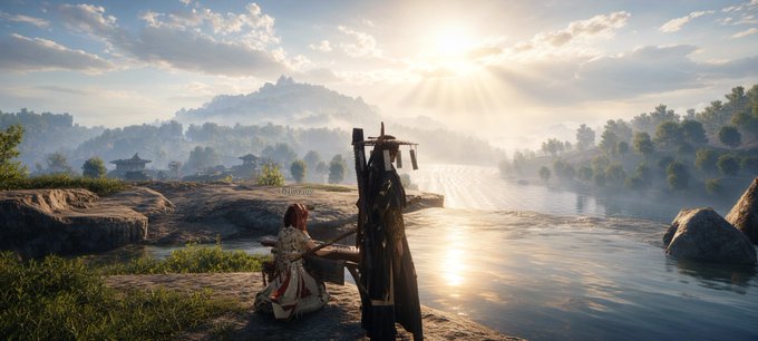 A scenic landscape showing a person in white and red robes kneeling by a lake at sunrise, with distant mountains and a sunburst lighting up the misty sky.