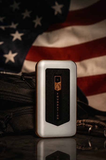 A "Foundation" branded offline 2FA device displayed against an American flag backdrop, with a tactical pouch and paracord visible. The image highlights the device's rugged, customizable nature—fitting the post's enthusiasm about being able to install personal apps and dive deep into its code for offline 2FA functionality.