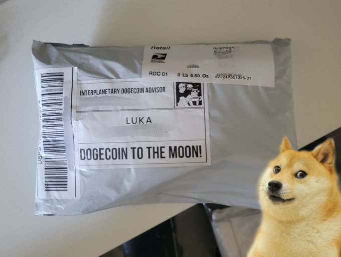 The image features a large, brown dog sitting next to a package that has been delivered via mail. The package appears to be from an interplanetary dogecin advisor (Luka) who sent it to the recipient's address. The dog is looking at the camera with a funny expression on its face, as if it knows something amusing about the delivery.