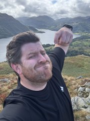 A man with a beard and black athletic shirt takes a selfie while flexing his arm, with a scenic lake and mountain landscape visible behind him. The image, captioned "Web3 Hiking Chad pt2 @spacebarSix9," fits the post's theme by showcasing the adventurous, outdoorsy lifestyle often associated with the "Web3 Hiking Chad" persona in crypto culture.