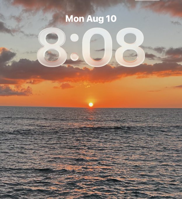 A smartphone lock screen showing the time "8:08" and date "Mon Aug 10" over a vibrant sunset/sunrise over the ocean.