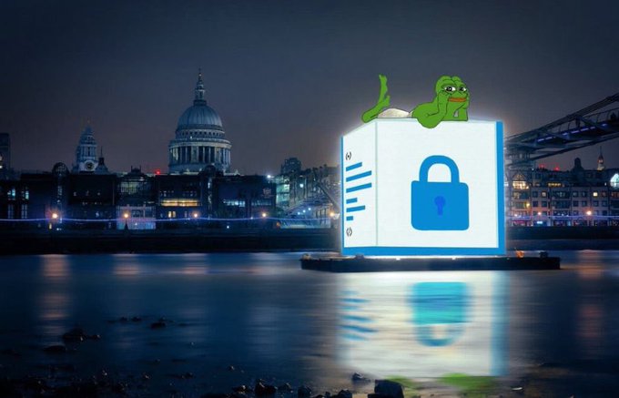 A nighttime cityscape featuring St. Paul's Cathedral and Tower Bridge in London, with a large floating digital cube displaying a blue padlock icon and the cartoon character Pepe the Frog lounging on top.