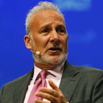 Peter Schiff, a prominent gold advocate and Bitcoin critic, is captured mid-speech wearing a gray suit and pink tie, gesturing with his hand as he discusses Bitcoin's surprising resilience during a market downturn in which U.S. equities fell. His puzzled expression in the image visually reinforces his public bewilderment over why Bitcoin rallied instead of selling off alongside traditional stocks.