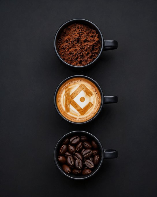 Three black coffee cups arranged vertically showcase the stages of coffee—ground coffee on top, a latte with latte art in the middle, and whole roasted beans on the bottom—visually representing the "beans, grind, and KuCoin" crypto trading joke. The stacked presentation cleverly mirrors the trading concept of grinding through market activity fueled by caffeine.