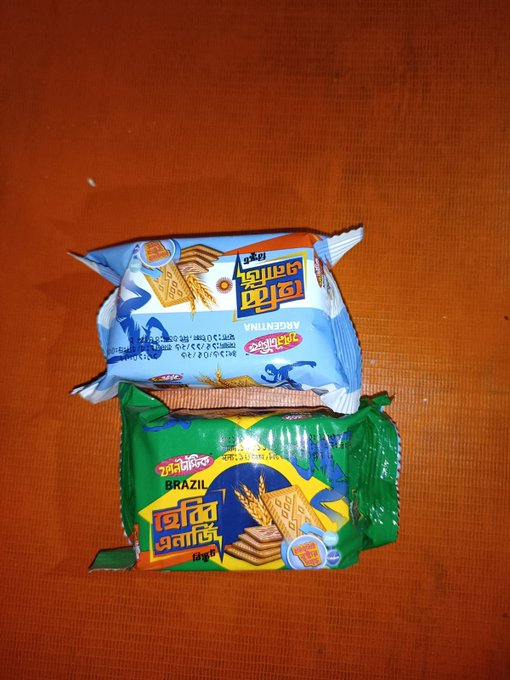 Two Parle-G biscuit packets—one labeled "Argentina" (blue wrapper) stacked atop one labeled "Brazil" (green wrapper)—rest on an orange surface, with the post highlighting the global scope of the speaker's exploration of Nucleus Codes in the Web3 space.
