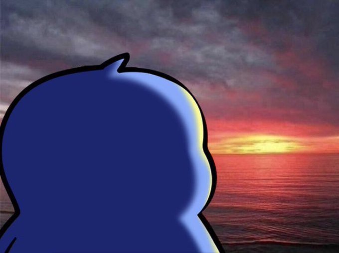 A blue cartoon character is shown from behind in silhouette, looking out at a dramatic ocean sunset with vibrant red, orange, and purple skies.