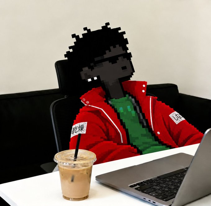 A person wearing a red jacket with green and white details sits at a desk with an iced coffee and a laptop, their face pixelated in a retro video game style.