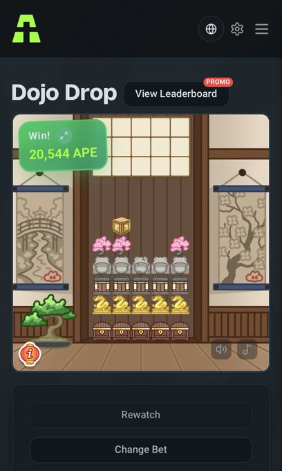 A mobile screenshot of the 'Dojo Drop' game app showing a 'Win! 20,544 APE' notification, with stacked cat statues, pigs, and golden toads on a wooden backdrop, plus 'Rewatch' and 'Change Bet' buttons.