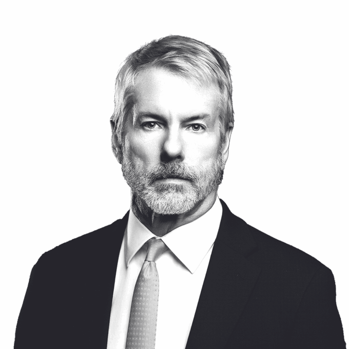 A black and white portrait of a gray-haired man with a beard, wearing a dark suit and light tie.