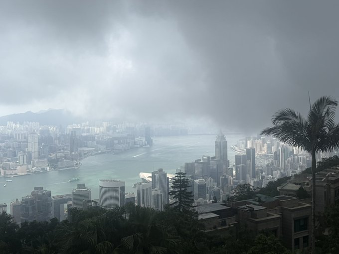 A foggy, overcast skyline of Hong Kong's Victoria Harbour is seen from a high vantage point, with the harbor flanked by dense skyscrapers fading into low clouds and mist.

The image doesn't directly illustrate the post's topic, but its moody, heavy atmosphere of dense infrastructure under oppressive weather visually echoes the post's theme of market pressure and shifting dynamics in the AI industry.