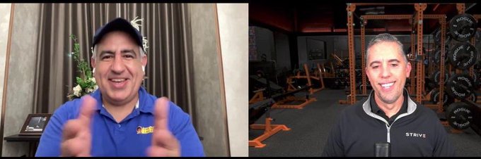A split-screen video call showing two men in athletic wear, one in a blue polo clapping his hands and the other in a black 'STRIVE' jacket in a gym setting.