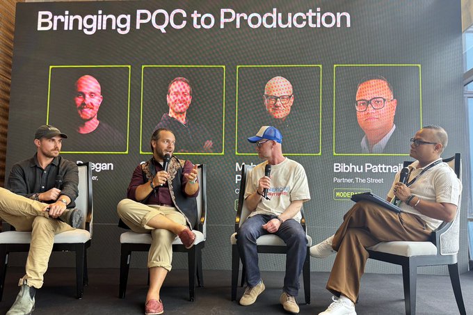 A panel discussion at a conference titled 'Bringing PQC to Production' featuring four men seated on stage with microphones, with headshots displayed on a screen behind them.