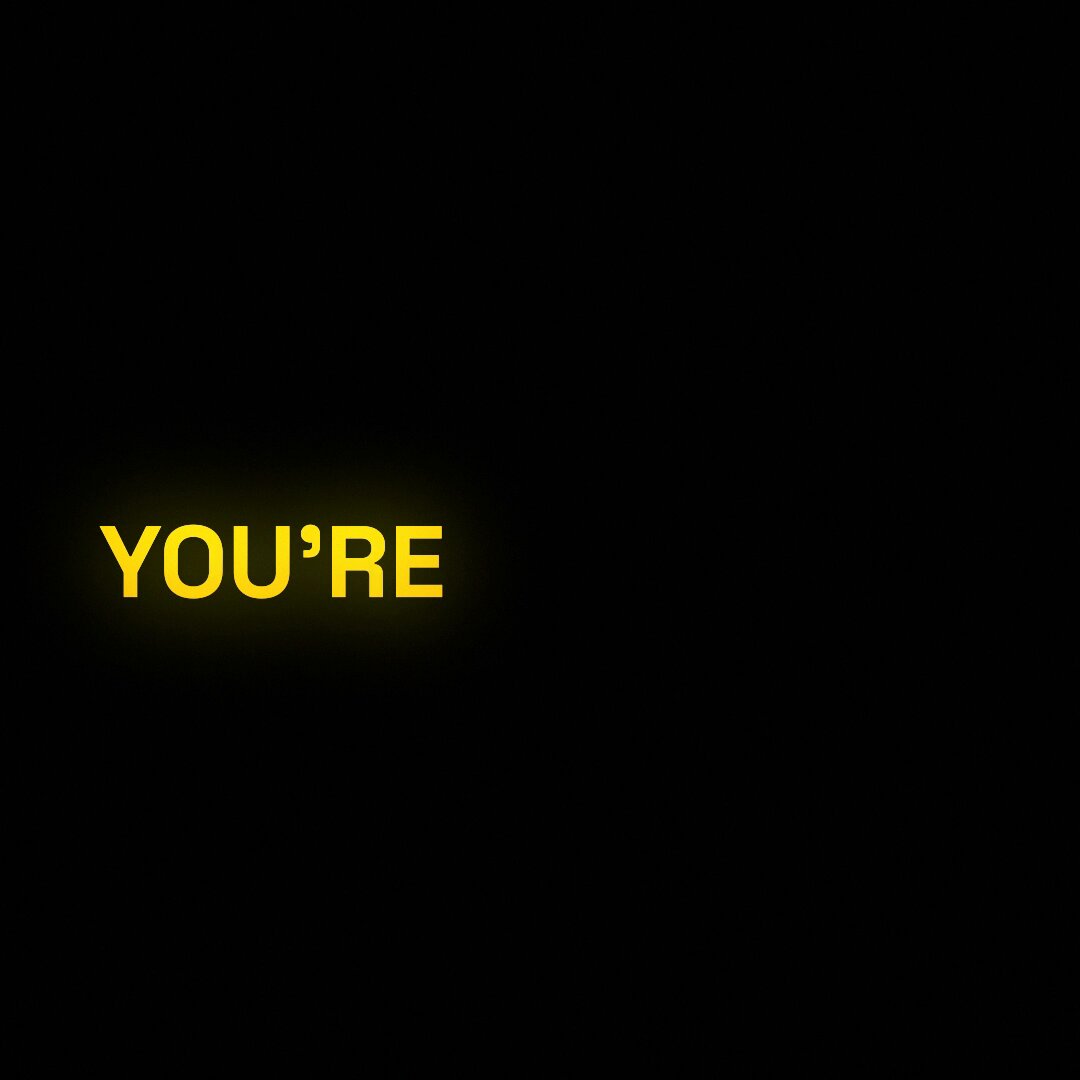 The image features a black background with yellow text that reads "You're", which appears to be a part of a joke or humorous statement. The caption below the image provides context, stating that there's a hackathon happening where participants are required to build a fully autonomous trading agent and compete against others to win.