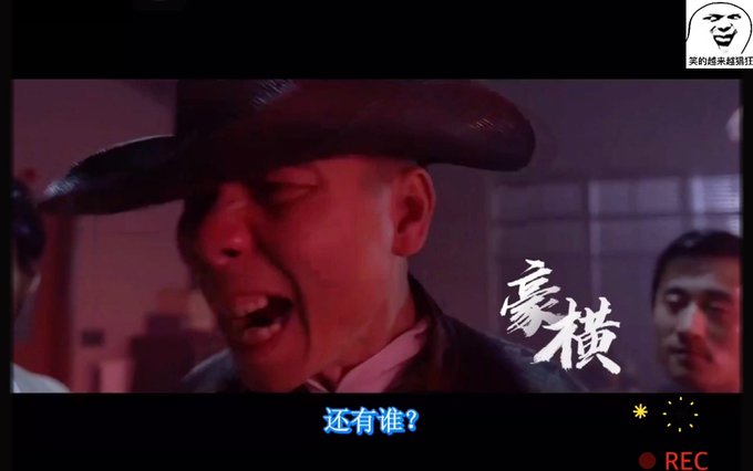 A red-tinted screenshot from a movie showing a man in a wide-brimmed hat yelling, with Chinese subtitles reading '还有谁？' and a 'REC' recording indicator.