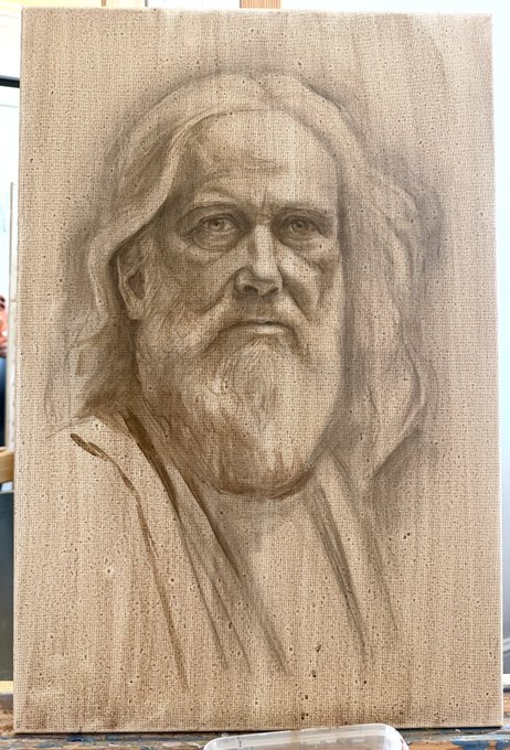 A detailed pencil or charcoal portrait drawing on canvas depicting an older man with long hair and a full beard, likely a work in progress on an easel.