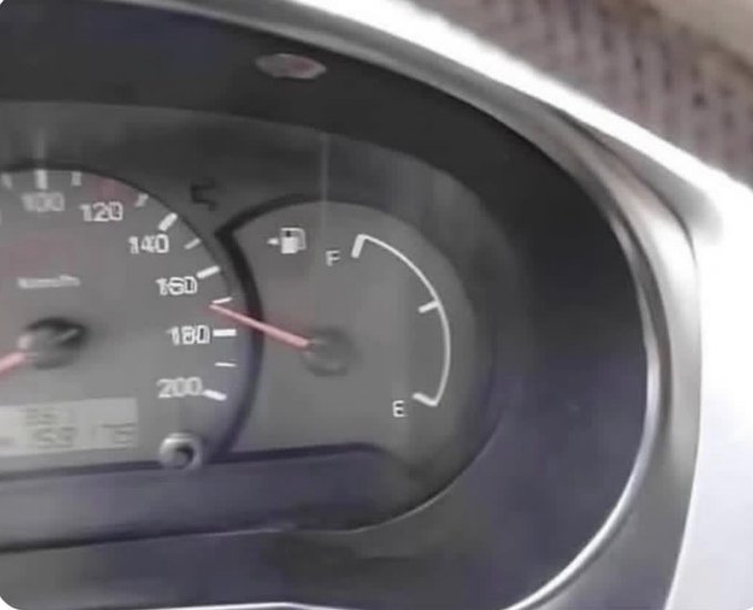 A close-up of a car's dashboard showing a speedometer reading up to 200 km/h and a fuel gauge indicating the tank is nearly empty near 'E'.