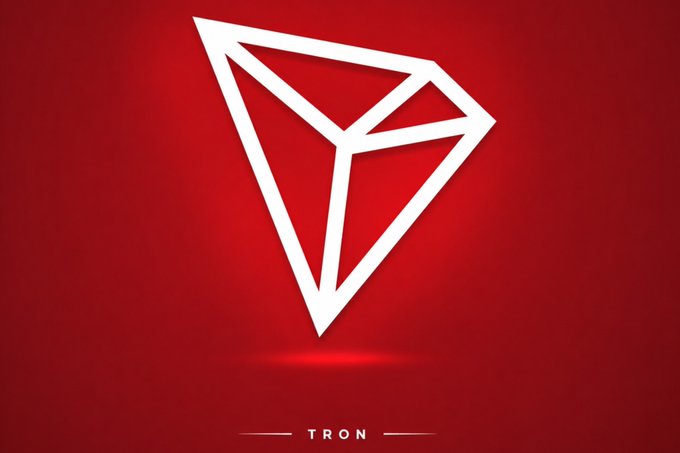 A white geometric diamond logo for 'TRON' cryptocurrency is displayed on a red background.