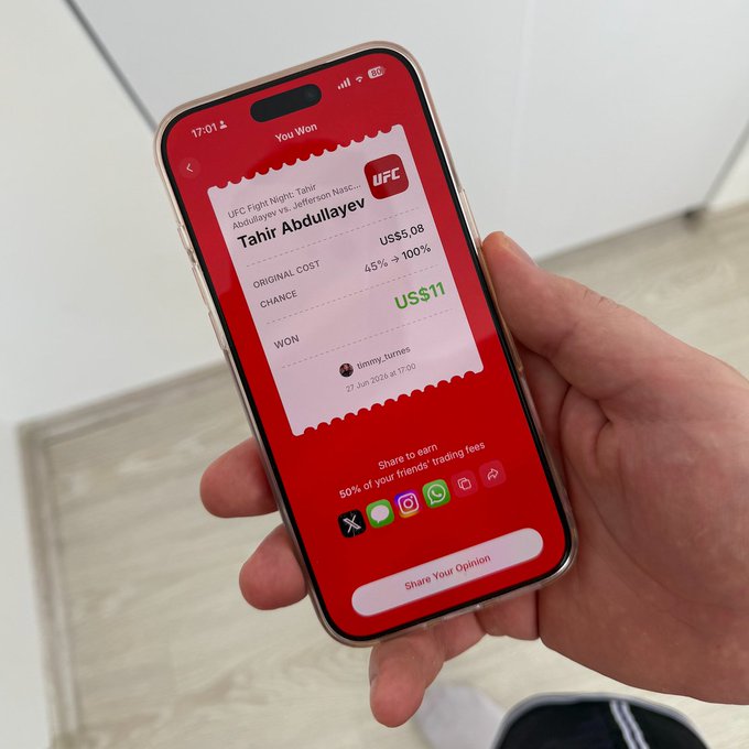 A hand holds an iPhone displaying a Polymarket prediction win on UFC Fight Night: Tahir Abdullaev vs Jefferson Nascimento, showing an original cost of US$5.08 at 45% chance now settled as a $11 win (65% → 100%), capturing the user's excitement about a successful prediction trade.