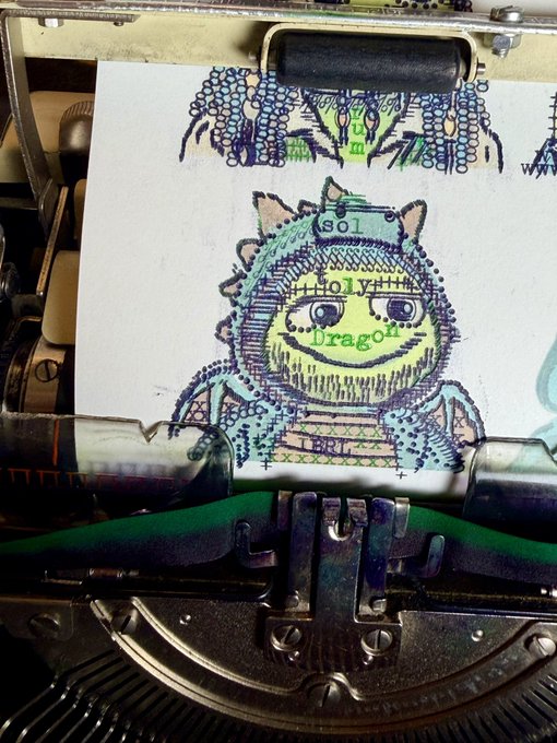 A close-up of a vintage typewriter printing a colorful illustration of a character wearing a knight's helmet labeled 'SOL', 'HOLY', 'Dragon', and 'BRT'.