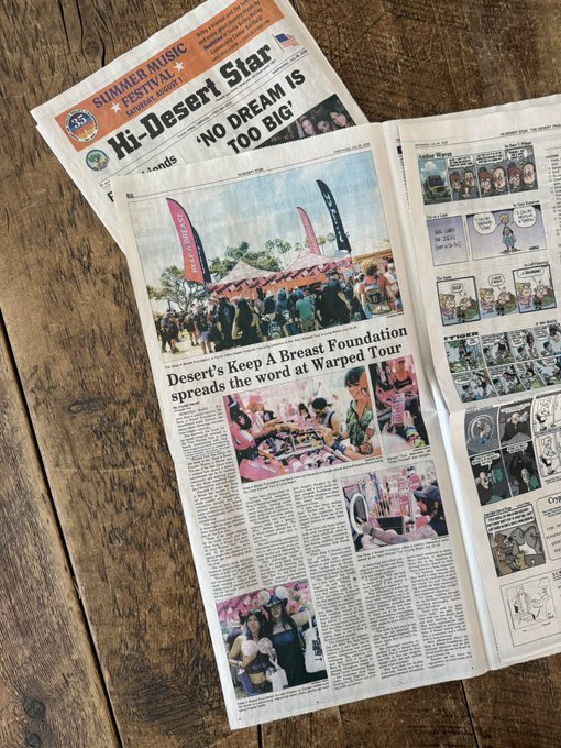 An open newspaper featuring headlines including 'Hi-Desert Star,' 'SUMMER MUSIC FESTIVAL,' 'NO DREAM IS TOO BIG,' and an article about 'Desert's Keep A Breast Foundation spreads the word at Warped Tour,' with comic strips visible on the right page.