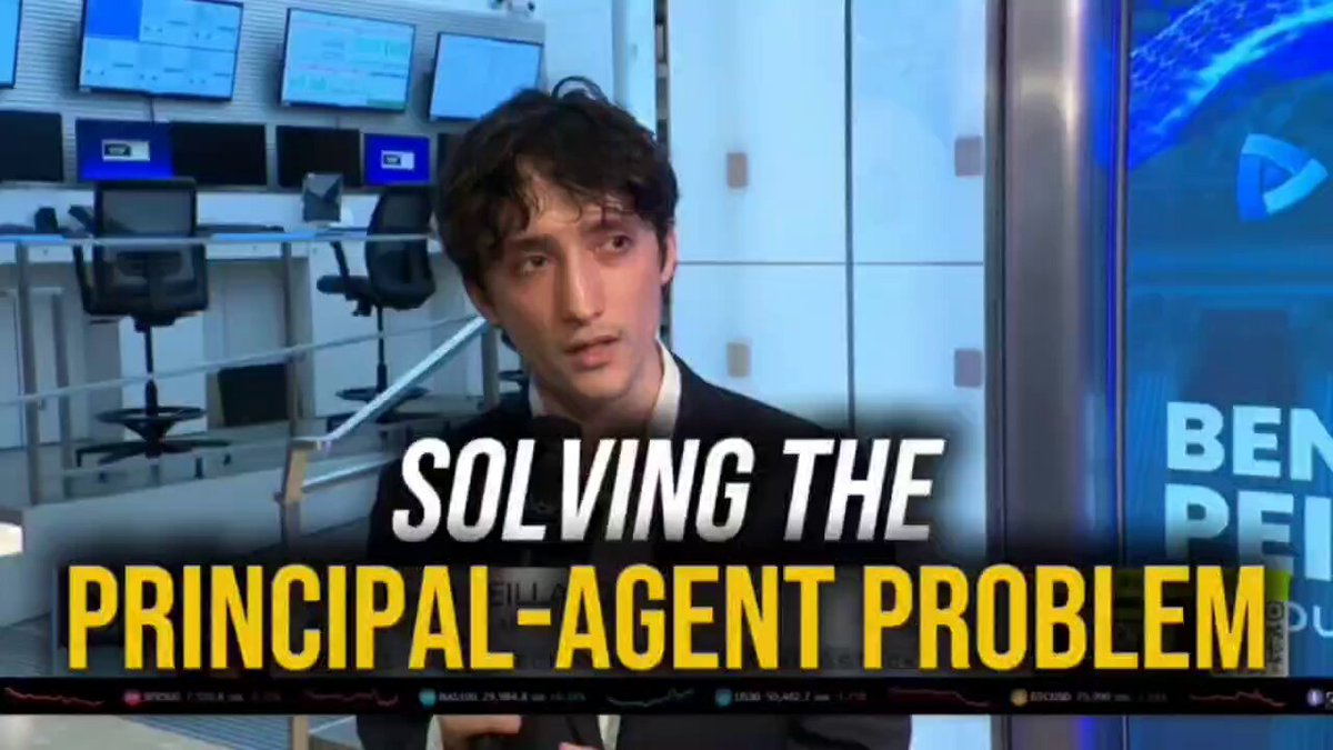 The image features a man wearing a black suit sitting at a desk with a computer monitor behind him. The text overlaying the image reads "Solving the Principal-Agent Problem", which suggests that the man might be discussing or explaining this concept related to the relationship between principals and agents in decision making processes.