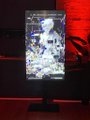 A vertically oriented smartphone displaying an image of a spacecraft against a reddish backdrop, mounted on a small stand.
