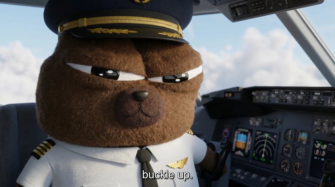 A determined-looking brown bear dressed as a commercial airline captain sits in the cockpit with the caption "buckle up." displayed at the bottom, humorously signaling preparation for the Monday ahead as referenced in the post about $BOBO.