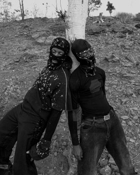 Two figures in black masks and dark clothing pose back-to-back against a tree in a rocky outdoor setting, presented as a black-and-white diptych that visually complements the post's "Illusion Of Control" theme and 0.2Ξ NFT collection.