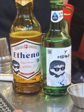 Two bottles of alcohol on a counter, one labeled 'Ethend' (whiskey) and another green bottle with a Korean label '여리고수' featuring an illustration of a girl with sunglasses.