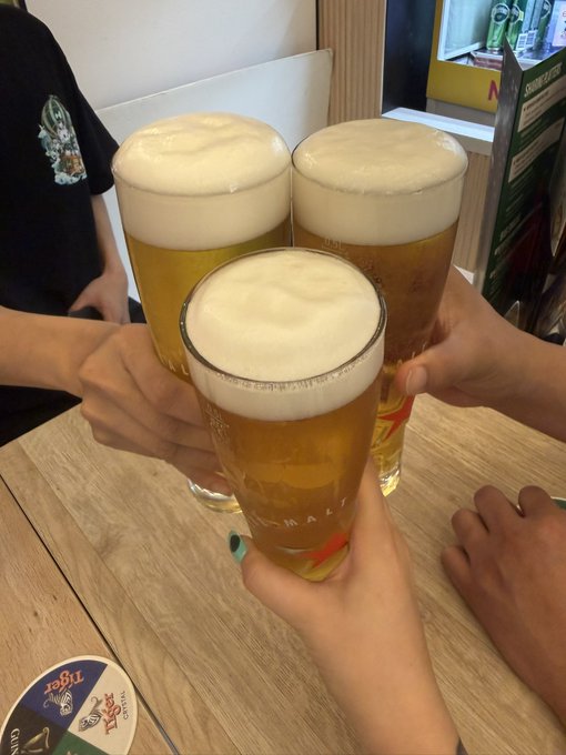 Three glasses of beer are clinked together in a toast on a wooden table at an airport gathering.

The image shows friends enjoying drinks together, which aligns with the post about a casual Hyperliquid meetup at the airport—capturing the social, celebratory spirit of the gathering before departures.