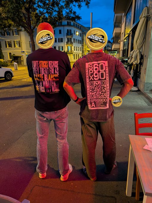 Two men stand on a city street at dusk wearing SPX-branded apparel, with one shirt reading "SMITE STOCK BECAUSE THEY TREAT FIN AS FREE BLACK" and the other displaying "S60 x90," a QR code, and "SPX6900," directly promoting the SPX6900 meme coin's "flip the stock market" message from the post.