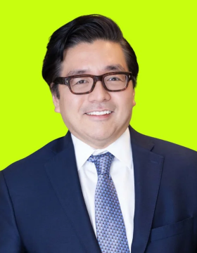 The image features a man wearing glasses, a suit with blue sleeves, and a tie. He has his head tilted slightly to one side as he smiles at the camera. The text accompanying the photo provides information about cryptocurrency prices and their relationship to Ethereum fundamentals.