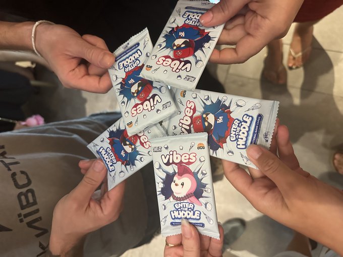Several hands gather in a circle holding "Vibes" snack packets featuring a cute penguin character with the text "Enter the Muddle," matching the post about visiting a Pudgy Penguins-themed hotpot and ending up with these branded "Vibes" treats.