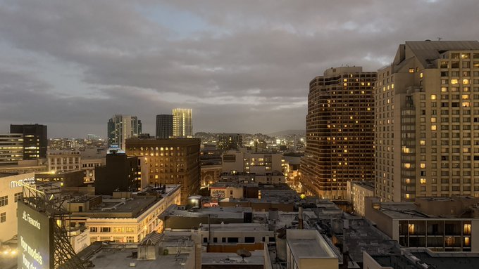 A cloudy evening view of a cityscape with high-rise buildings and a Macy's sign visible.