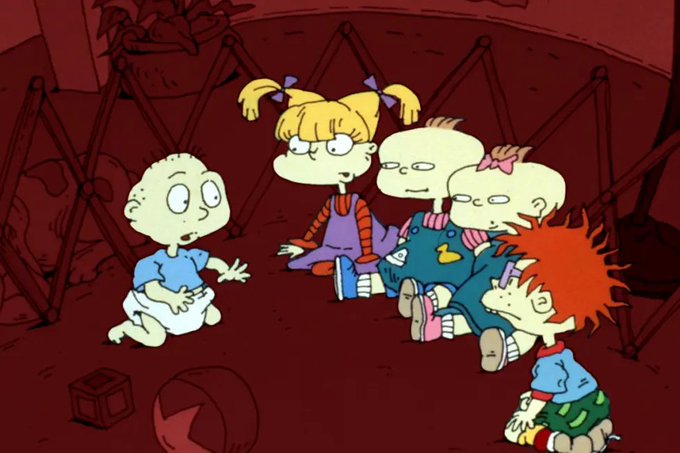 Scene from the animated show Rugrats showing the babies Tommy, Angelica, Phil, Lil, and Chuckie sitting together in what appears to be a playpen.
