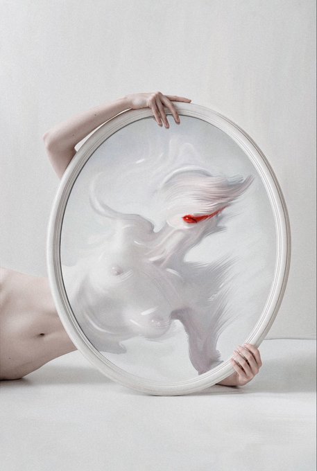 Surreal art photograph showing a person holding a large oval mirror that reflects a distorted, ghostly white figure with flowing hair and red lips instead of the person itself.