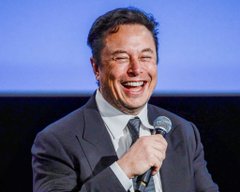 A man wearing a black suit is holding a microphone, smiling widely while giving his speech or presentation. The caption says "BREAKING: ELON musk SAYS AI CANNOT "CRACK BITCOIN" HE SAID AI MAY IMPROVE THEEFFICIENCY OF BITCOIN MINING HARDWARE BUT IT CAN'T OVERRIDE FUNDAMENTAL MATH". This image appears to be related to the post about using Artificial Intelligence (AI) for cryptocurrency mining.