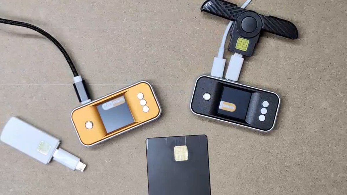 The image shows a collection of three electronic devices placed on a table or countertop. The devices include two USB cards connected to a computer, one black and one gold, as well as a white device with a plug-in cord. The devices are arranged in such a way that they appear ready for use, possibly for charging or connecting to the internet.