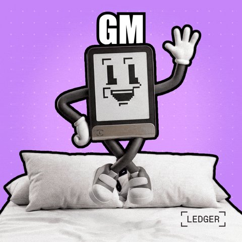 The image features a cartoon character standing on top of a bed, waving at the camera while wearing white shoes. The character appears to be a small robot or tablet with arms and legs, giving off a playful vibe. The background of the image is purple, which complements the overall theme of the post. The caption reads "gm Ledger these small morning check ins honestly became one of the calmest parts of my routine everything online moves so fast now that having a simple moment to just show up, slow down, and reconnect with the mindset behind all this feels weirdly grounding it's also a good".