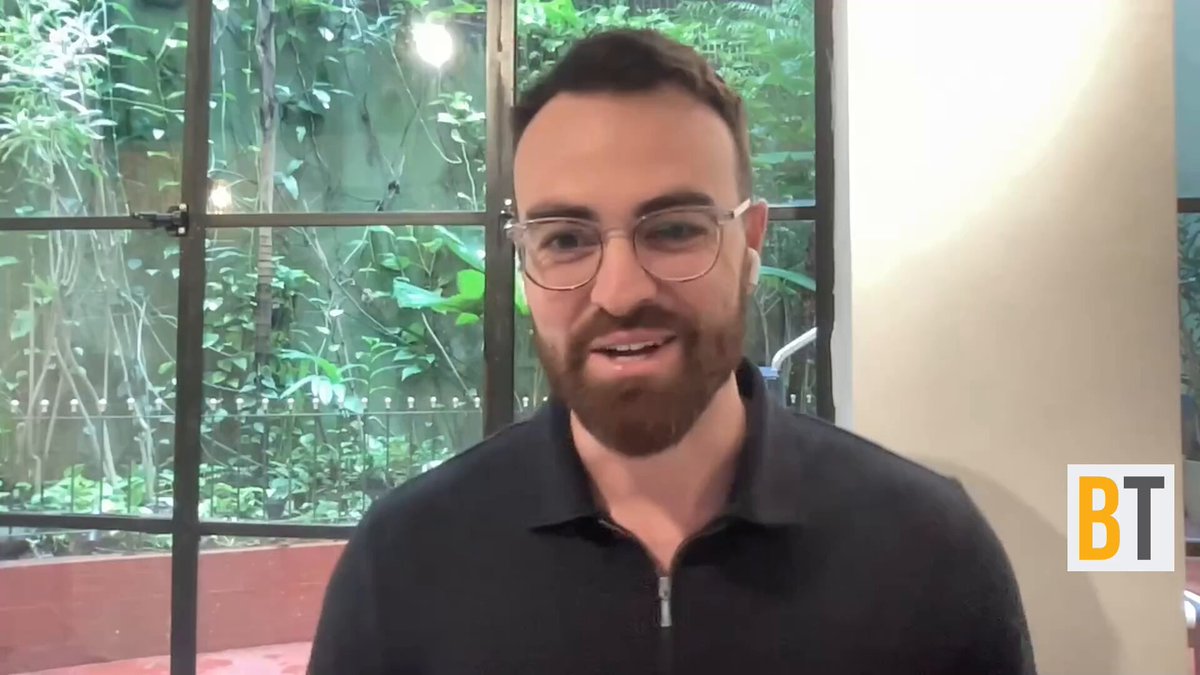 The image shows a man wearing glasses, standing in front of a window, and smiling at the camera. The caption reads "Just In: @ChasePalmieri just said @Strive's $SATA is having a breakout moment ... that's a real moment for Strive." This post seems to be discussing the stock market or financial news related to companies like $SATA.