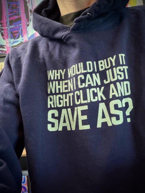 A person wears a dark blue hoodie featuring the text "WHY WOULD I BUY IT WHEN I CAN JUST RIGHT CLICK AND SAVE AS?"—a humorous nod to online piracy culture, directly mirroring the caption's commentary on saving digital content for free instead of purchasing it.