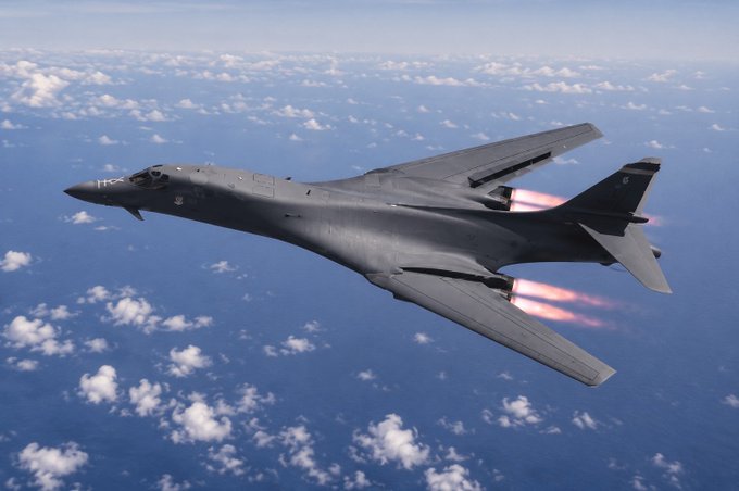 A military jet flies at high altitude above the clouds with afterburners glowing, evoking the imagery of war and military conflict. The image visually reinforces the post's claim that armed conflicts serve as catalysts for geopolitical and financial shifts, suggesting that war—often backed by banking interests—drives the global adoption of alternative assets like XRP.

No visible text, numbers, tickers, or names appear in the image itself.