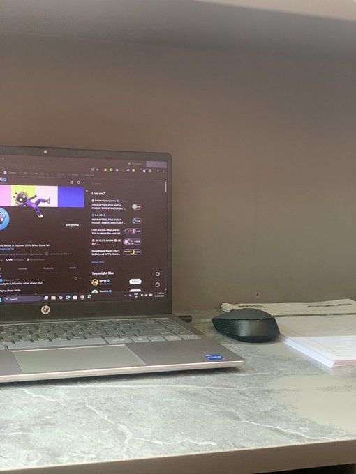 A laptop on a marble desk displays the Discord application with various chat channels visible on the screen.