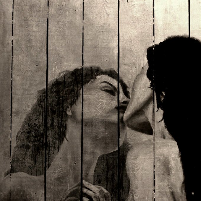 The image features a painting of a woman's face, which appears to be a self-portrait or an artistic representation of herself. The painting is displayed behind a wooden fence, giving it a rustic appearance. The artist has used a black and white color scheme for this piece, adding a timeless quality to the artwork. The image also includes text that reads "Freshly minted NFT" and "She had to love herself first", which could be related to the artist's inspiration or message behind the painting.