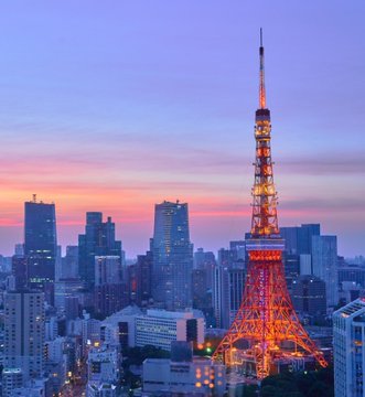 Tokyo Tower illuminated against a vibrant sunset skyline, representing Japan's financial hub as the country moves toward 24/7 blockchain-based settlement infrastructure for bonds and stocks, led by the government, Bank of Japan, and financial institutions.