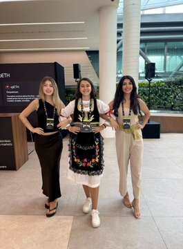 Three women pose at what appears to be the ETH Belgrade conference, with two wearing lanyards and one sporting a traditional embroidered dress—matching the post's joke about the "Belgrade dress code memo." Visible signage in the background reads "ETH Belgrade," tying the image to the crypto Twitter-to-irl crossover mentioned in the caption.
