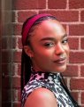 A young girl with braided hair wearing a magenta headband poses against a red brick wall, with "#MYSTORM" suggesting the image is a personal or branded photo shared under that hashtag.