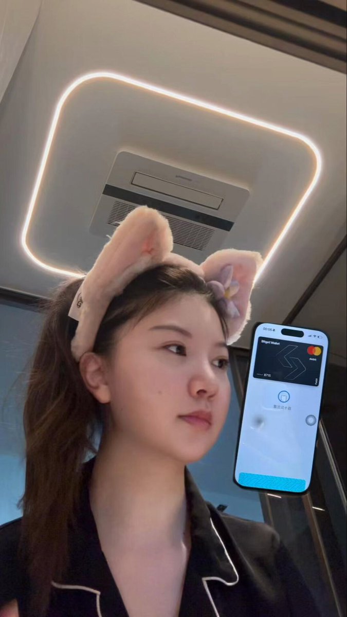 The image features a woman wearing a cat ears headband, standing next to an iPhone displaying a wallet app called "Bitget Wallet". The woman appears to be posing for a photo with her phone and earrings, while the wallet app on her phone is likely related to cryptocurrency or digital currency.

The post suggests that the woman might need a Cryptocurrency Survival Plan, which could include using Bitcoin wallets like Bitget, as well as other digital currency options. The image also includes a reference to "Crypto Survival Plan" and "bitget wallet", indicating that the app is related to cryptocurrency or digital currency management.

The post emphasizes the importance of understanding how to use various cryptocurrencies and managing digital assets effectively in today's world.